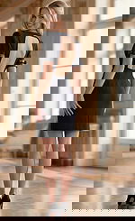 Back view of Jovani 36690 black mini dress featuring a dramatic open back cutout, structured short sleeves with leather buckle cuff accents, and zipper closure at the lower back.