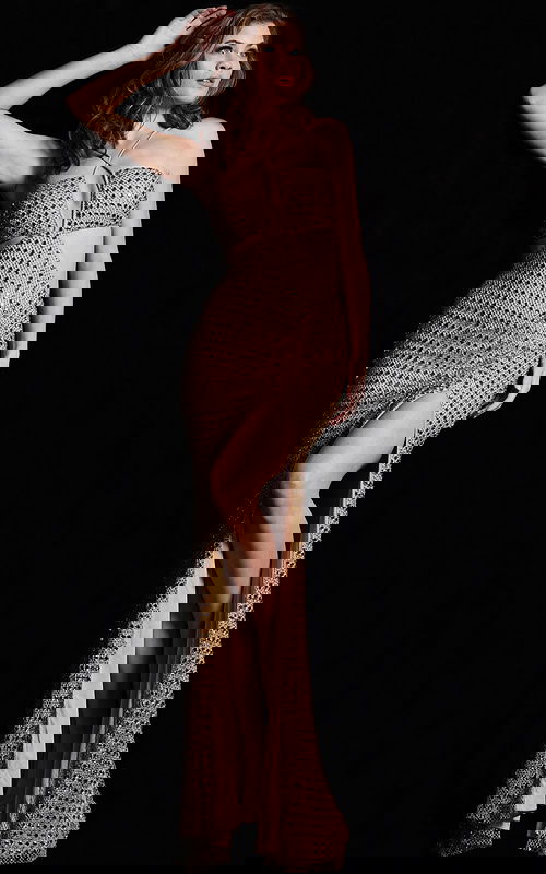 Model wearing Jovani 36810, gold beaded gown with halter neck and high slit front view.