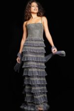 Model wearing Jovani 36816 silver gown with intricate sequined patterns and square neckline.