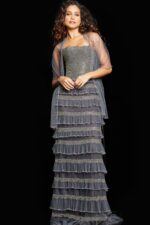 Full view of model wearing Jovani 36816 silver gown with sequined bodice and layered ruffles.