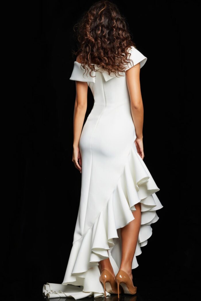 Model wearing Jovani 36910 white gown with off-the-shoulder neckline and ruffle detail, back view.