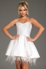 Model wearing 36979 white dress with sweetheart neckline featuring feathered hem.