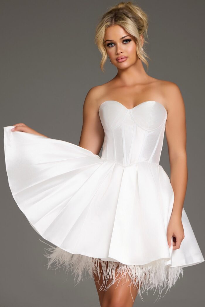 Model in 36979 white knee-length dress with corset bodice and feathered hem.