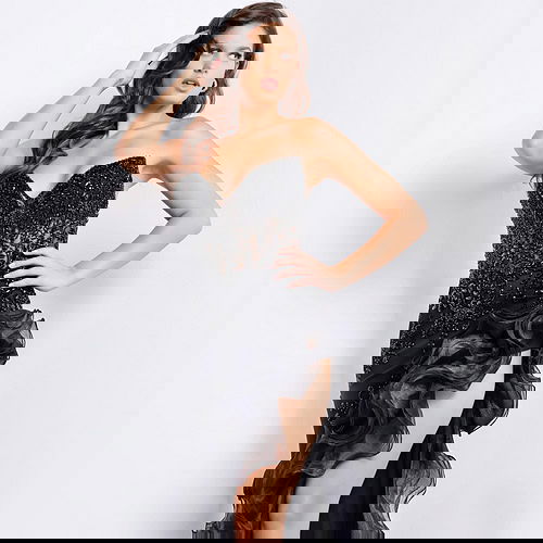 Model wearing Jovani 37036 black gown with ruffled high slit and embellished bodice from the front