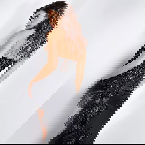 Model showing the back of Jovani 37036 black gown with embellished details