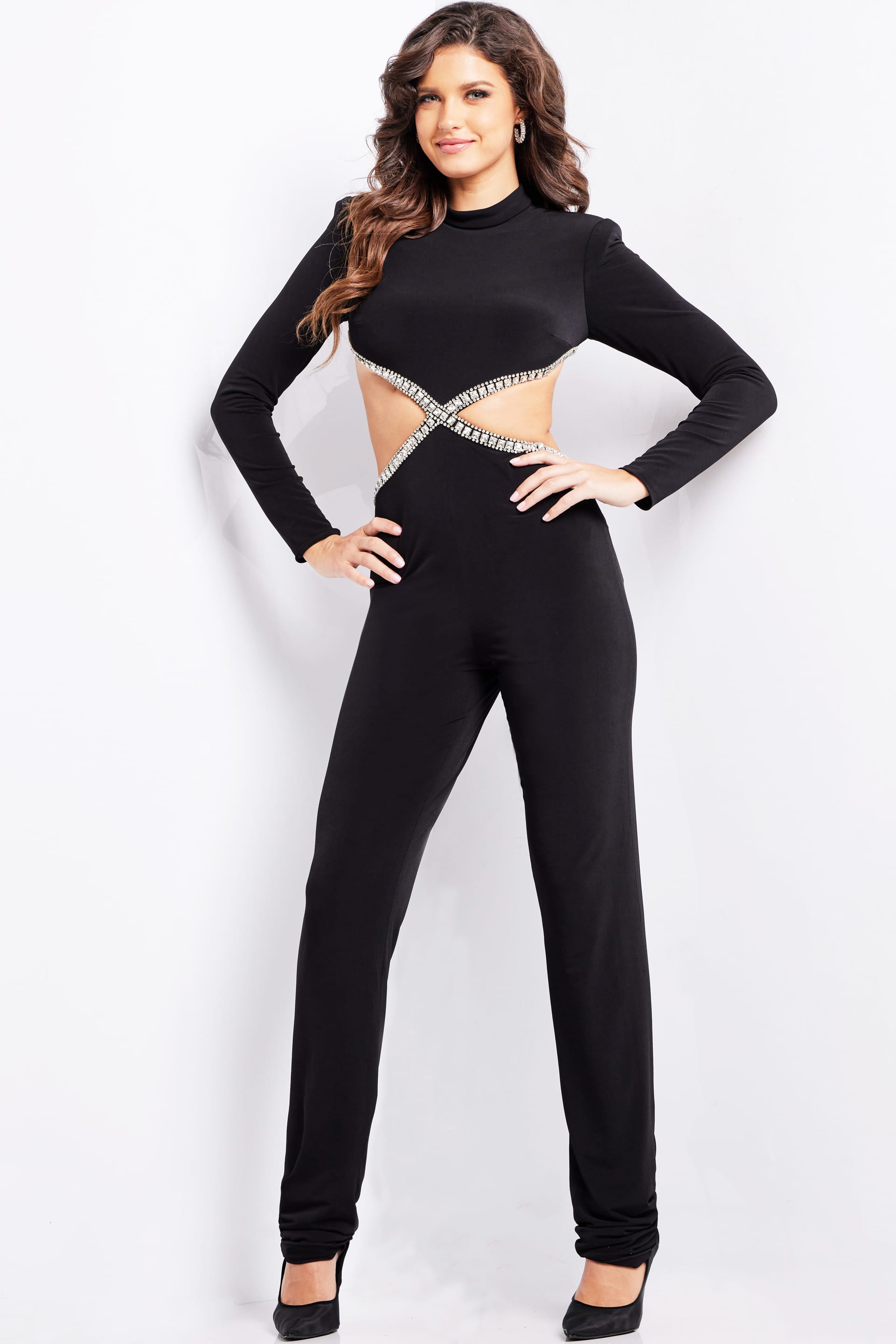 37038_BLACK_3-2.jpg Model wearing Jovani 37038 black jumpsuit with long sleeves and cutout detailing.