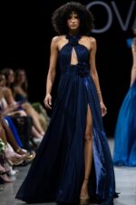 Full front view of Jovani 37163 navy gown with high slit on runway.