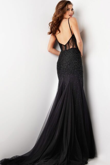 Model wearing Jovani 37202 black gown with low back and strappy detailing, back view.