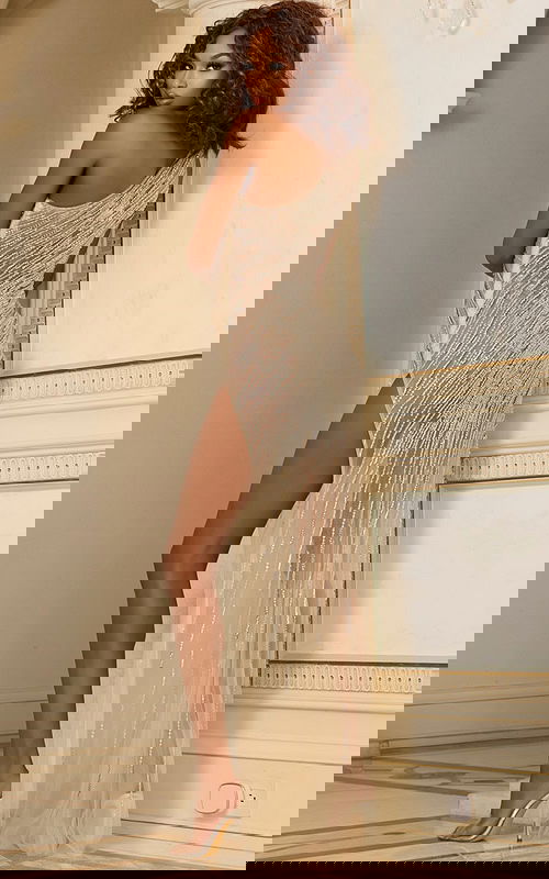 Back view of model in Jovani 37211 nude gown with shimmering details and high slit.