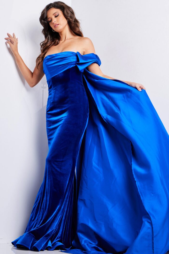 Back view of Jovani 37390 royal blue gown with cape flowing elegantly.