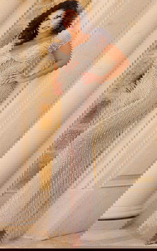 Model wearing Jovani 37401 gown with beading and puff sleeves.