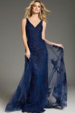 Model in Jovani 37600 navy gown with V-neckline and elegant lace embellishments from the front.