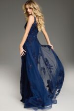 Side view of model in Jovani 37600 navy gown showcasing the flared silhouette and sheer overlay.