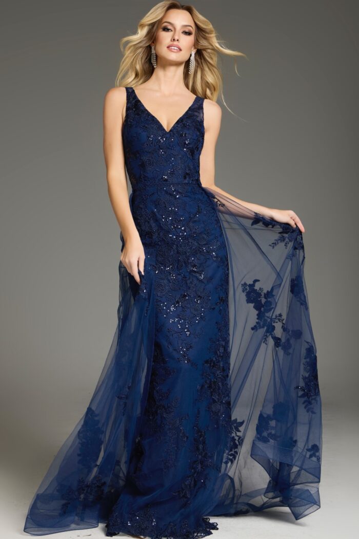 Model in Jovani 37600 navy gown with V-neckline and elegant lace embellishments from the front.