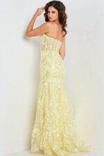 Back view of model wearing Jovani 38004 yellow dress with floral details.