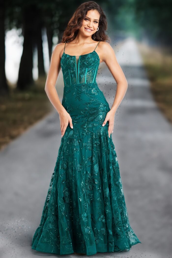 Model wearing Jovani 38004 dark green gown with elegant floral design, street view.