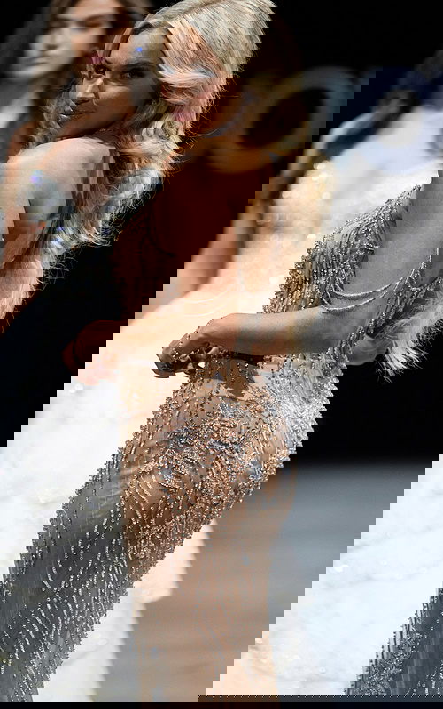 Model wearing 38249 nude gown with embellished details, back view.