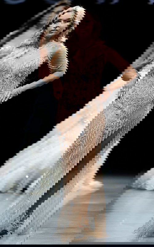 Model wearing 38249 nude gown with embellished details and high slit, front view.