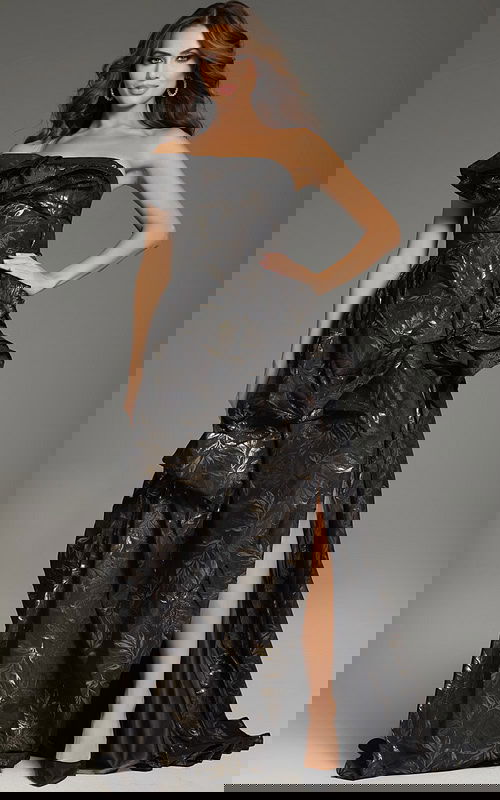 Model wearing Jovani 38265, a brown one-shoulder gown with gold floral accents and a high slit.