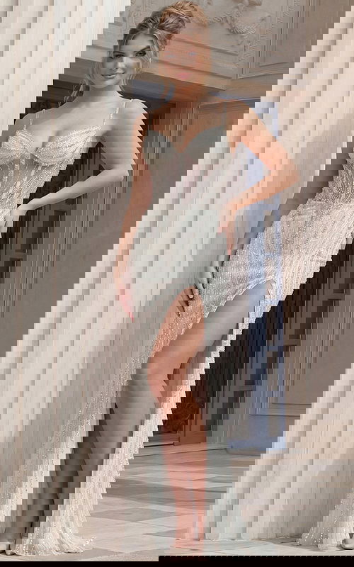 Beaded fitted gown with sheer corset bodice, thin straps, and front slit