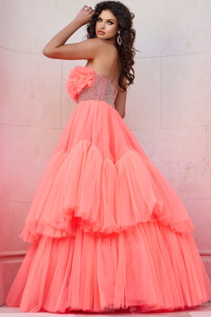 Model wearing Jovani 38299 orange gown with floral ruffles and embellished waist, side view.