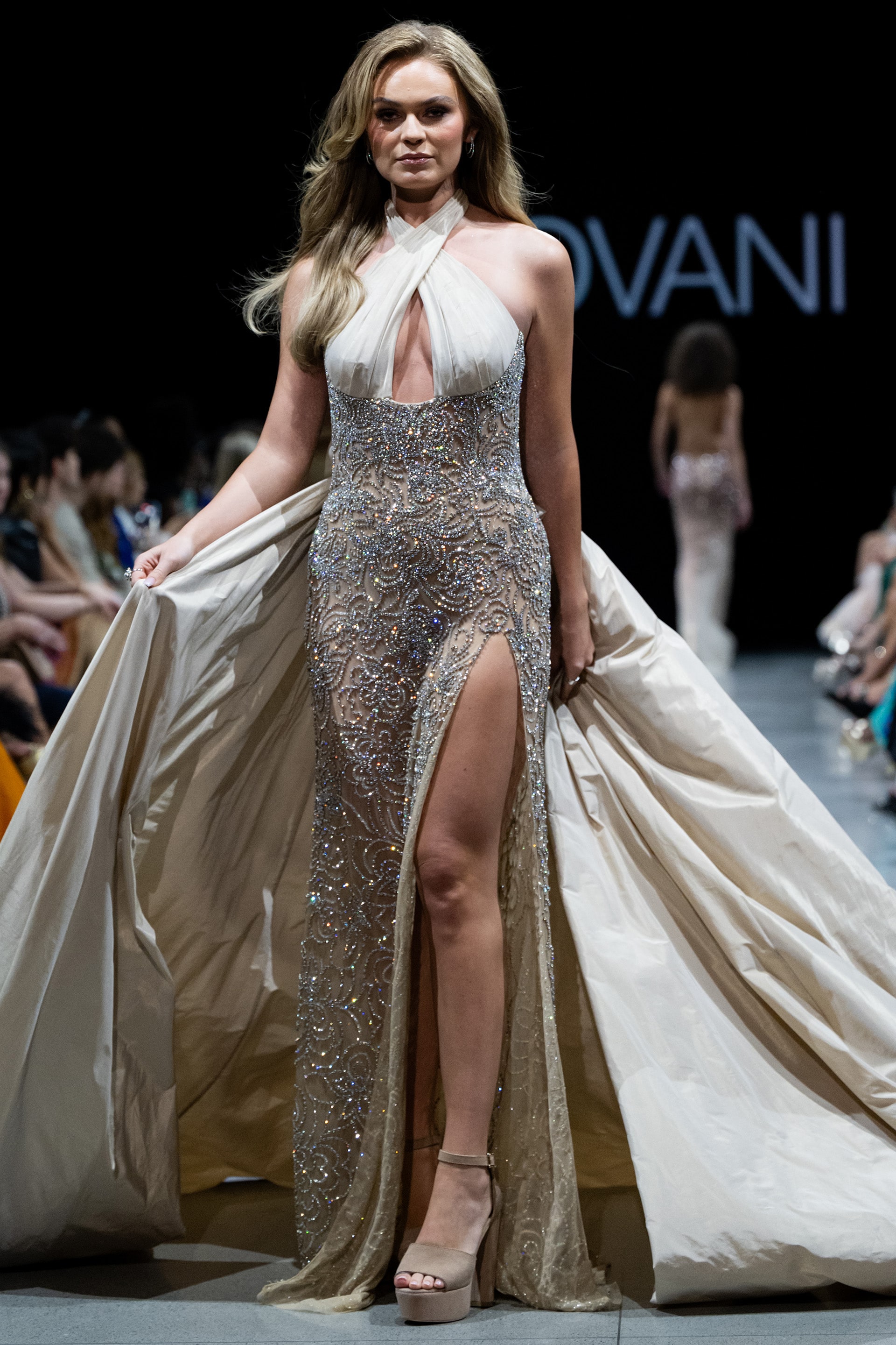 38442.jpg Model wearing Jovani s38442 gown with elegant halter neckline and high slit, embellished with sparkling beading.