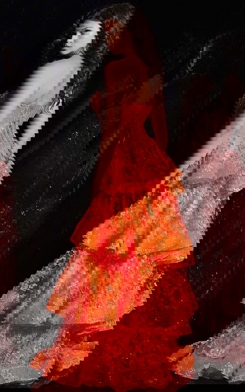 Model wearing Jovani 38528 orange dress showcasing the back with tiered ruffles