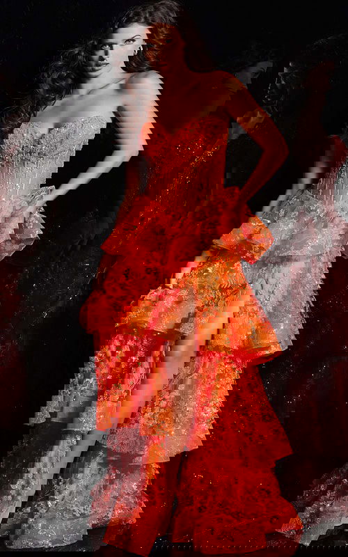 Model wearing Jovani 38528 orange gown with floral embroidery and tiered ruffles from the front