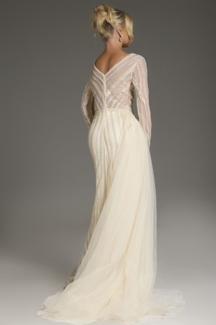 Back view of model wearing Jovani 38581 gold dress with sheer detailing.