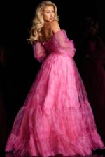 Back view of model in Jovani 38605, a fuchsia gown featuring an off-the-shoulder neckline and flowing A-line shape.