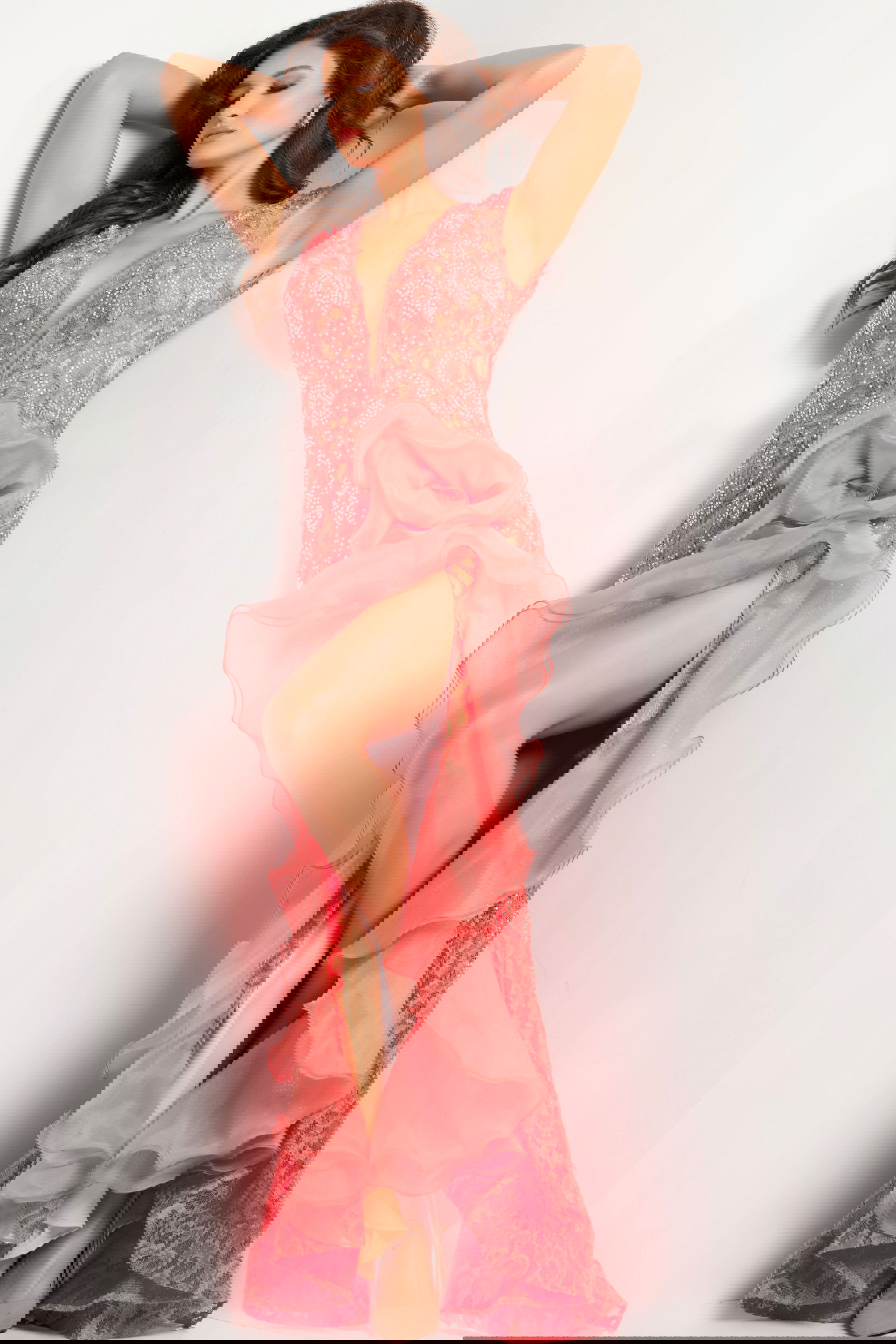 38668_CORAL_26-2.jpg Model wearing Jovani 38668 coral dress with high slit and ruffle detail.