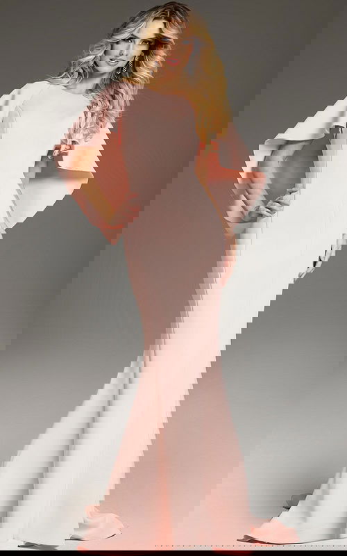 Model wearing Jovani 38822 in blush with a mermaid silhouette and cape sleeves.