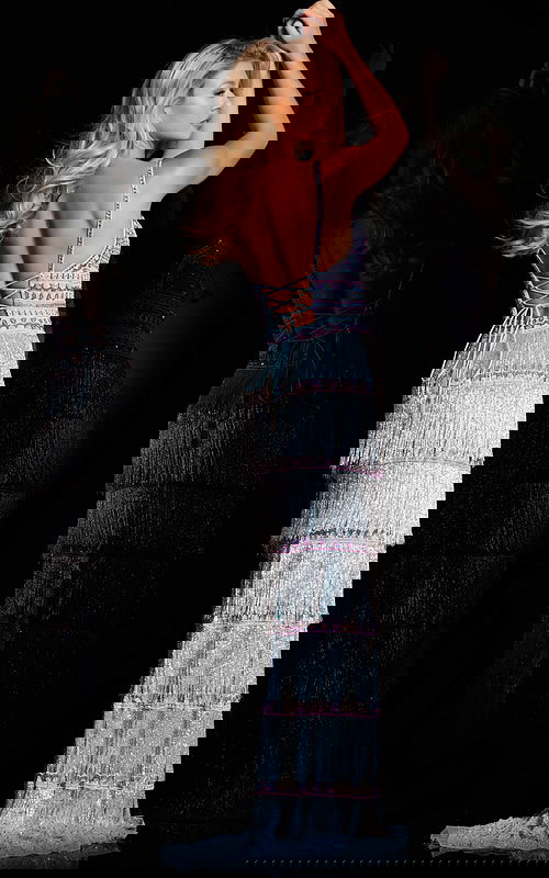 Model wearing Jovani 38846 blue gown showcasing open back and crisscross design, back view.