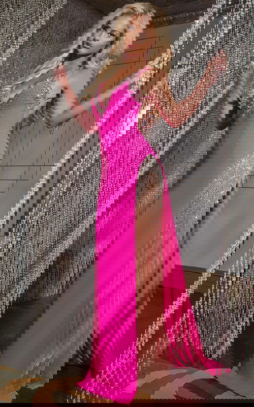 Model wearing Jovani 38983 pink dress with V-neckline and high slit from the front.