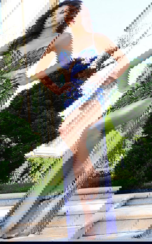 Model wearing Jovani 39039 royal dress with deep V-neckline and high slit.