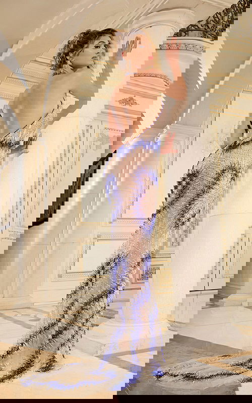 Back view of model wearing Jovani 39037 royal blue gown with open back detail