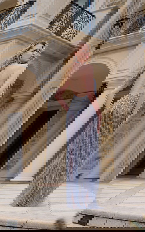 Model wearing Jovani 39063 gray dress with a backless design, detailed embellishments, viewed from the back.