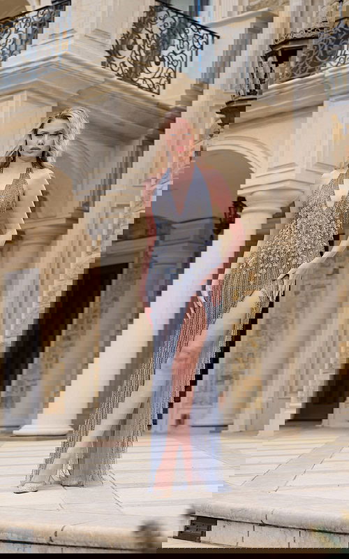 Model wearing Jovani 39063 gray dress with deep V-neckline, intricate beadwork, and high slit, viewed from the front.