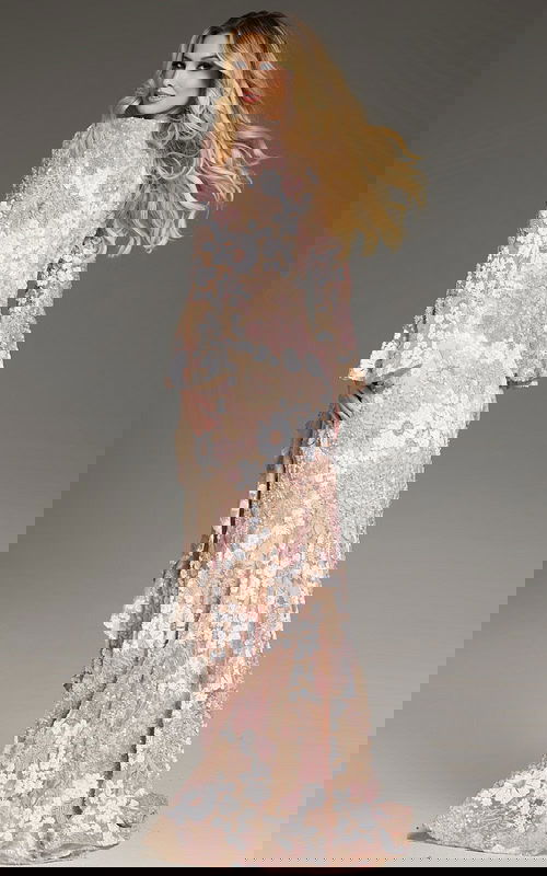 Model wearing Jovani 39118 nude gown showing back view with floral embroidery.