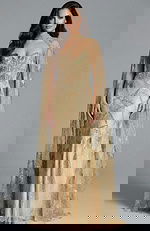 Model wearing gold strapless embellished gown with sheer beaded cape and intricate sequin pattern.