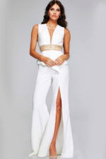 Model in Jovani 39720 ivory jumpsuit with deep V-neck and gold waist, full front view.