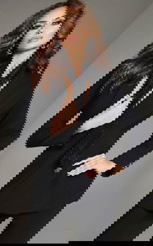 Model wearing Jovani 39726 black outfit with deep V-neckline and long sleeves.