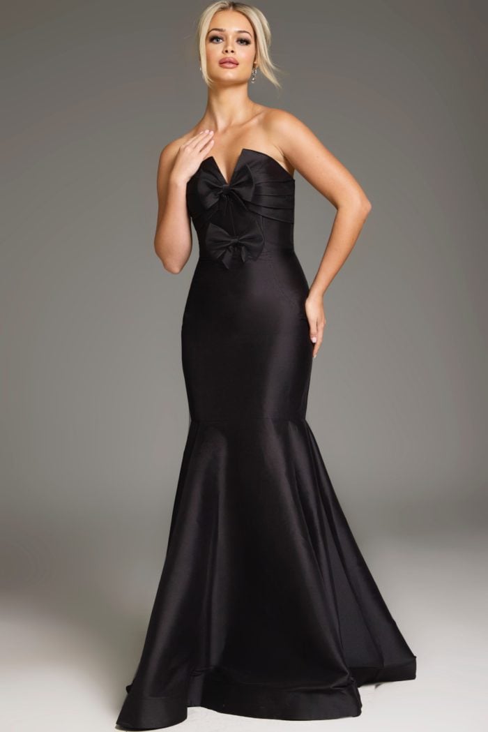 Model wearing Jovani 39872 black mermaid gown with bow detail front view