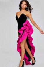 Model wearing Jovani 39885 black gown with fuchsia ruffle and high slit.