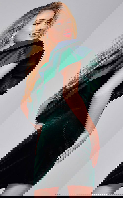 Model wearing Jovani 39888 green mini dress with one-shoulder ruffles, back view.