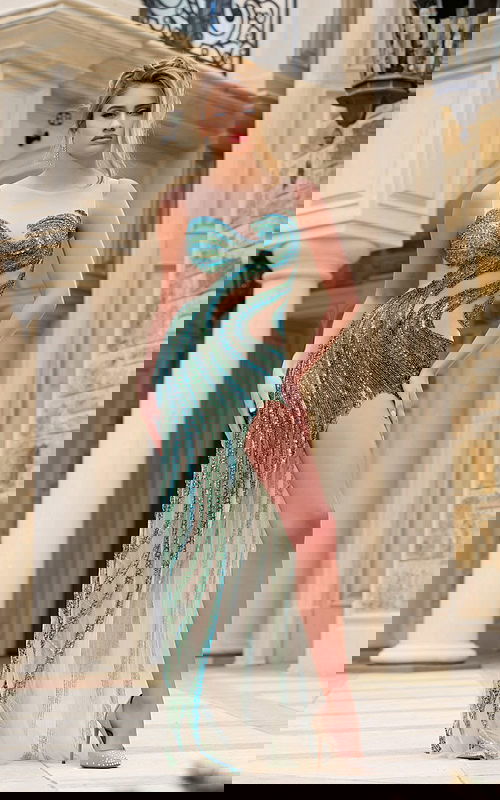 Model wearing Jovani 39943 green gown with high slit, front view.