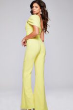 Model wearing Jovani 39961 yellow one-shoulder jumpsuit, back view.