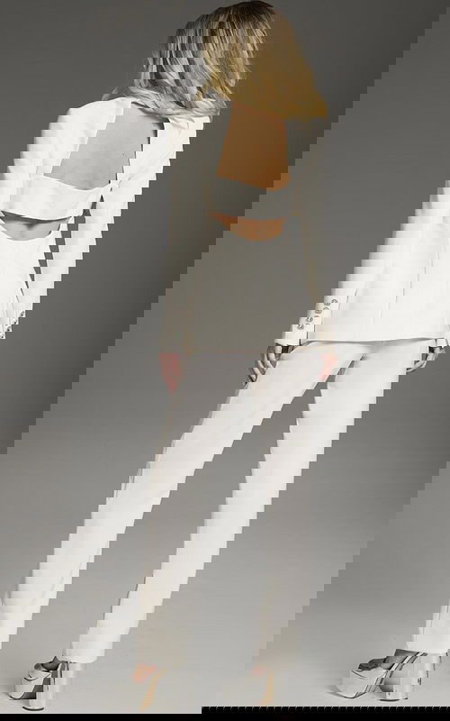 model wearing Jovani 39969 ivory suit with cutout blazer and tailored trousers