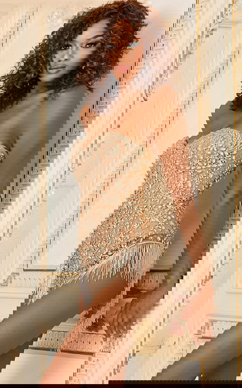 Model wearing Jovani 40090 nude dress with floral embellishments and fringe detailing, front view