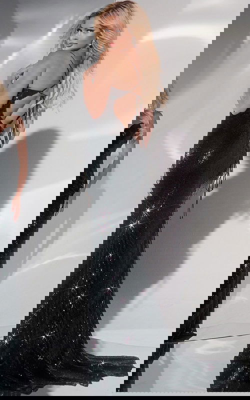 Model wearing Jovani 40100 black gown, showcasing stunning open back with criss-cross straps.